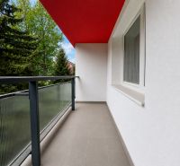 Balcony from a 2-room apartment with a red ceiling and railing with glass.