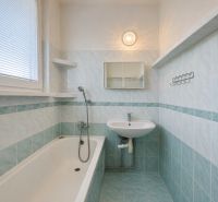 Bathroom with a bathtub and a sink, blue tiles in a 2-room apartment.