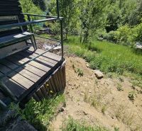 A cottage in Budatín with a terrace and a view of greenery and a slope.