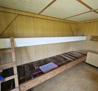 Interior of a cabin with a bunk bed, wooden decor flooring, and a wooden wall.