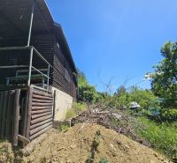 A cabin structure in Budatín surrounded by nature and greenery, wooden elements.