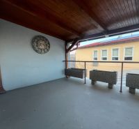 Covered terrace with clocks and flower pots in the production area.
