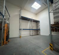 Warehouses and halls with high shelves and a skylight, concrete floor.