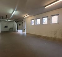 The interior space of warehouses and halls with windows and a garage door.