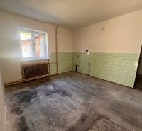 A room in a family house with a window, a radiator, and light green tiles.