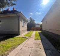 A family house in Vrakúňa with a concrete walkway and a grassy area.