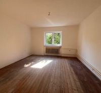 Interior of a family house with a wooden decor floor and a window overlooking greenery.