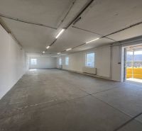 Spacious interior of warehouses and halls with concrete flooring and plenty of natural light.