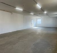 A spacious empty interior with a concrete floor and white walls in warehouses and halls.