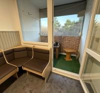 A bright loggia of a 4-room apartment with a view and wooden furniture.