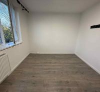 A bright room with a wood-decor floor and a radiator in a 4-room apartment.