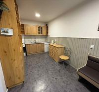 A kitchen in a 4-room apartment with wooden cabinets and a floor with a wooden decor.