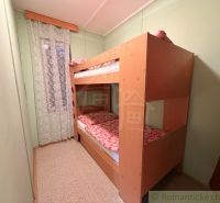 Bunk bed in a cabin room with a curtain with a floral pattern.