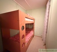 Bunk bed in a cottage, bright room with soft lighting.