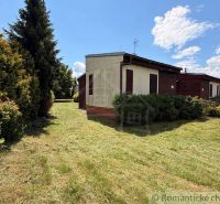 A cottage in Nové Zámky with a garden and a sky full of clouds.