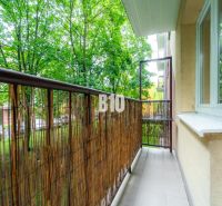 A balcony in a 2-room apartment with a view of greenery, surrounded by trees in the city of Martin.
