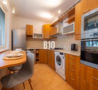 A kitchen in a 2-room apartment with a wooden decor and appliances.
