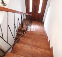 A staircase in a family house with a wooden decor floor and metal railing.