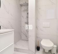 A bathroom in a 2-room apartment with a modern shower and white sanitary ware.