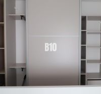 Built-in wardrobe with sliding doors in a 2-room apartment with shelves for storage space.