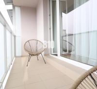 A balcony with seating in a 2-room apartment with a tiled floor.