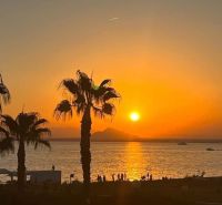 Sunset with palm trees and the sea in La Manga del Mar Menor, Spain.