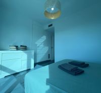 Recreational apartment with a bright room, bed, dresser, and balcony in blue tones.