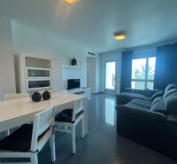 Dining table with chairs and a sofa, holiday apartment, floor with wooden decor.