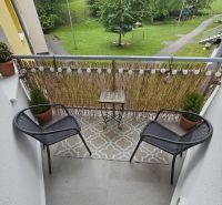 The balcony of the 3-room apartment offers a view of greenery and a children's playground.