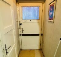 The entrance hallway in a 3-room apartment with older doors and light-colored walls.