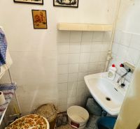 A small bathroom with a sink and decorations in a 3-room apartment.