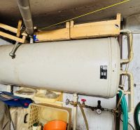 Boiler in the technical room of a 3-room apartment, pipes, hoses, walls.