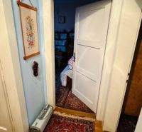 A room in a 3-bedroom apartment with a carpet and open doors, floor with wood decor.
