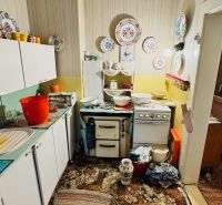 A kitchen with vintage decor in a 3-room apartment and a carpet with a colorful pattern.