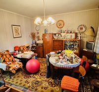 A room full of vintage furniture and decorations in a 3-room apartment with a wood-patterned floor.