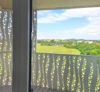 A balcony with a panoramic view and a wooden decor floor in a 2-room apartment.