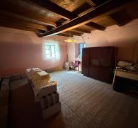 A room in a family house with furniture, stacks of bricks, and a wooden ceiling.