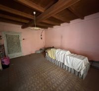 A room in a family house with antique lighting and a beamed ceiling.