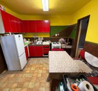 A family house with a kitchen, red cabinets, and white appliances.
