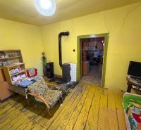 Living room in a family house with a stove, yellow walls, and a floor with a wood decor.