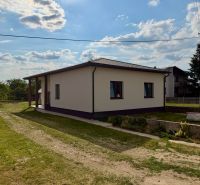 A family house in Zemplínska Široká surrounded by greenery, with a clear sky above the roof.