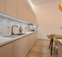 A kitchen with an elegant countertop, modern sink, and decorative lighting in a family house.