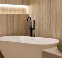 Freestanding bathtub with a modern black faucet in a family house.