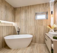 A bathroom in a family house with a freestanding bathtub, wooden decor, and pendant lighting.