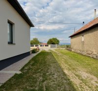 A family house in Zemplínska Široká with a lawn between the buildings and a maintained walkway.