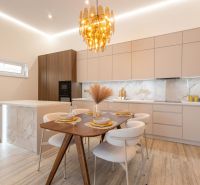 Dining room in a family house with marble decor on the walls and a wooden table.