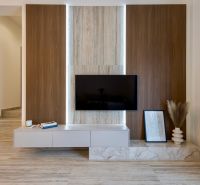 Interior of a family house with a wall featuring wooden decor, a television, and decorations.