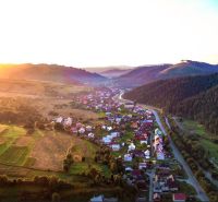 The landscape around Nová Bystrica with agricultural and forest lands at sunset.