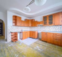 A kitchen with wooden cabinets and tiled backsplash in a 3-room apartment.