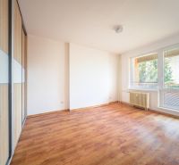 A room in a 3-room apartment with a wooden decor floor and large windows.